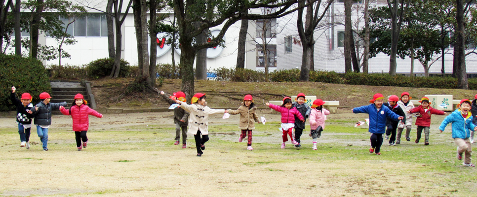 手作りの凧で遊んでいる子どもたち